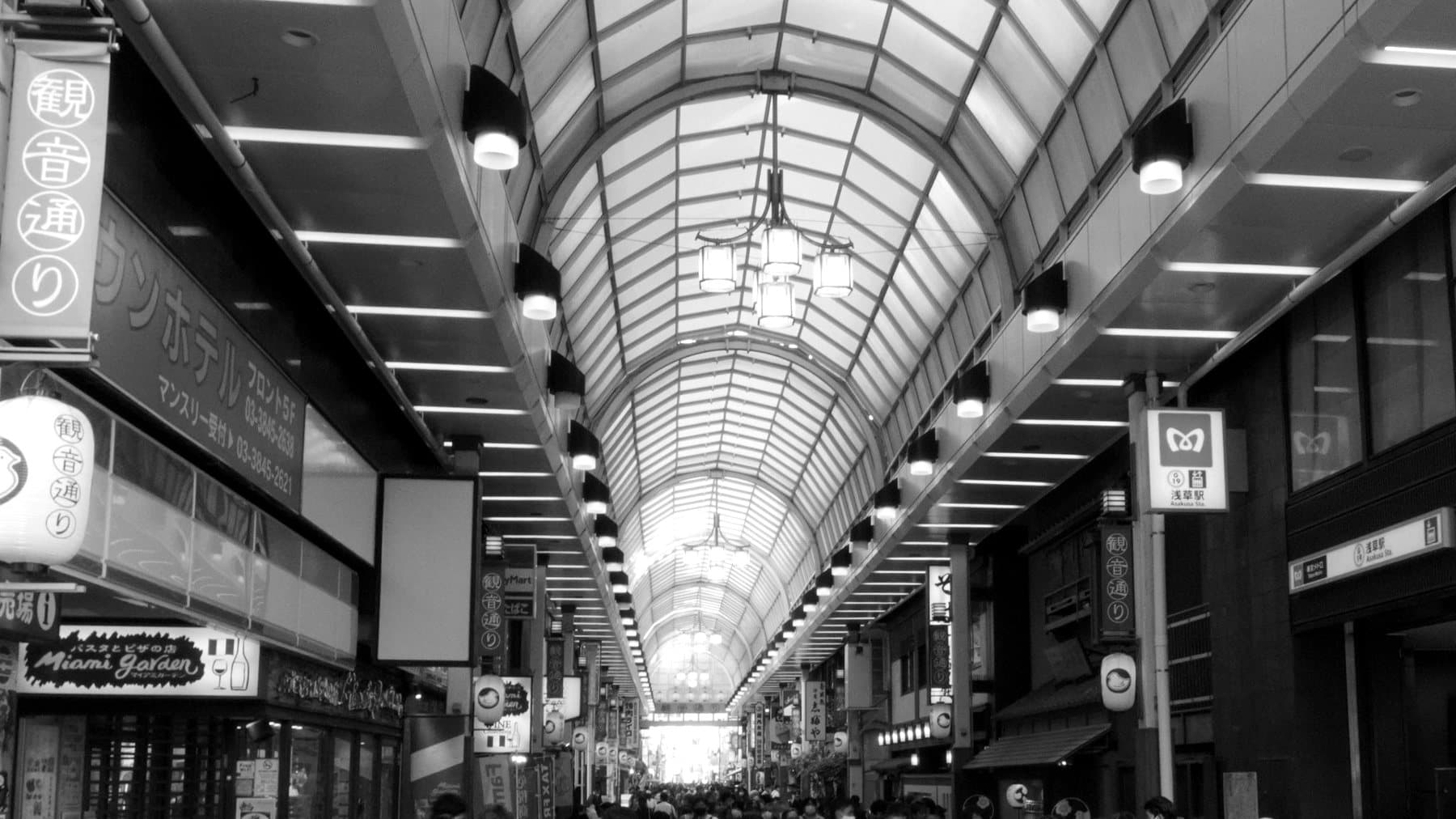 A covered shopping arcade in Tokyo lined with small storefronts.